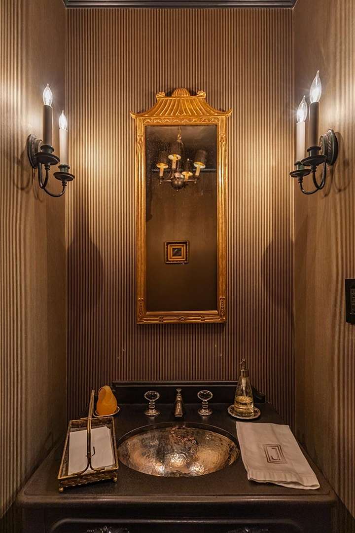 Bathroom with gold mirror and black counter at Audrey Hepburn's former LA mansion