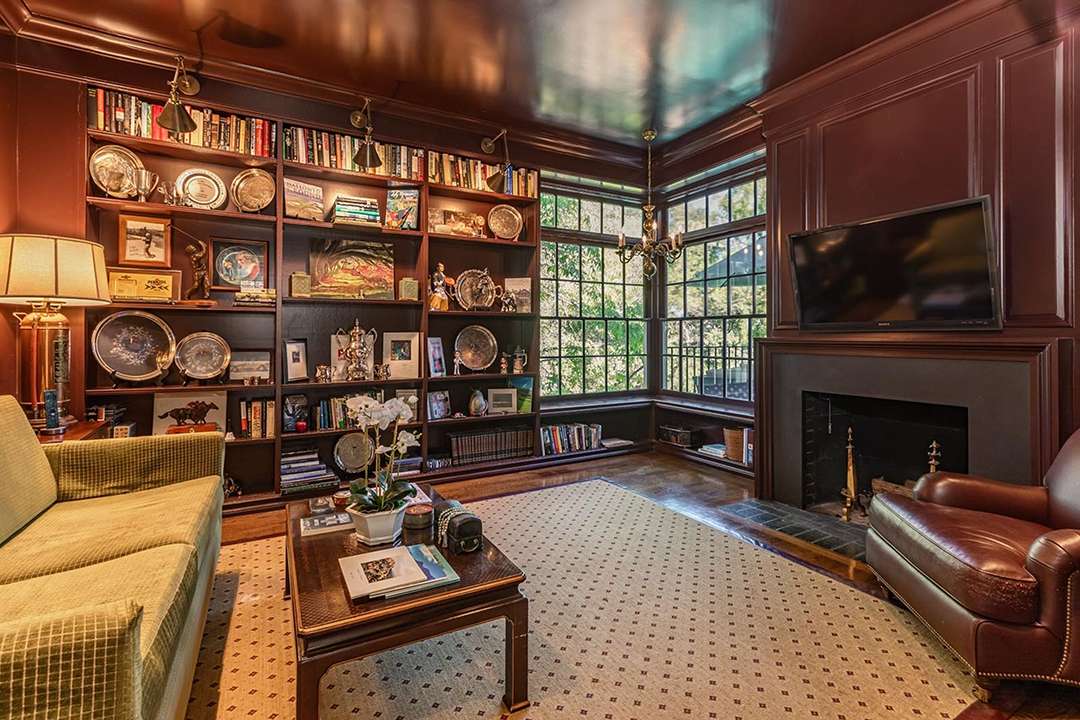 Wood living room with fire place and built-in shelves at Audrey Hepburn's former LA mansion