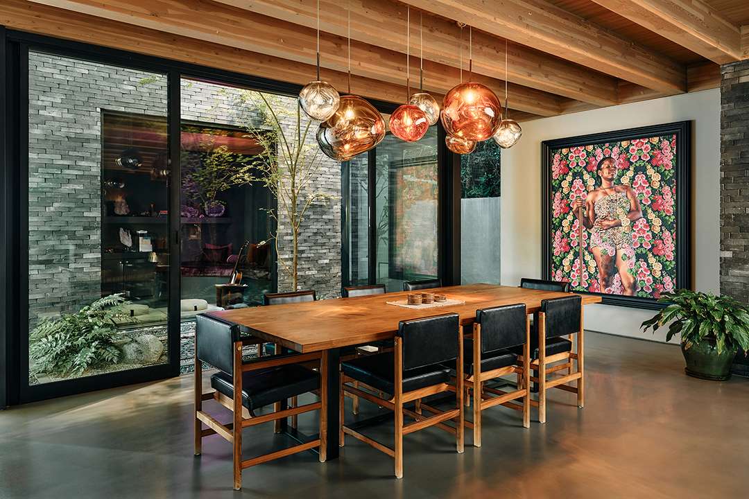 Lizzo's dining room with wood table and black woman painting