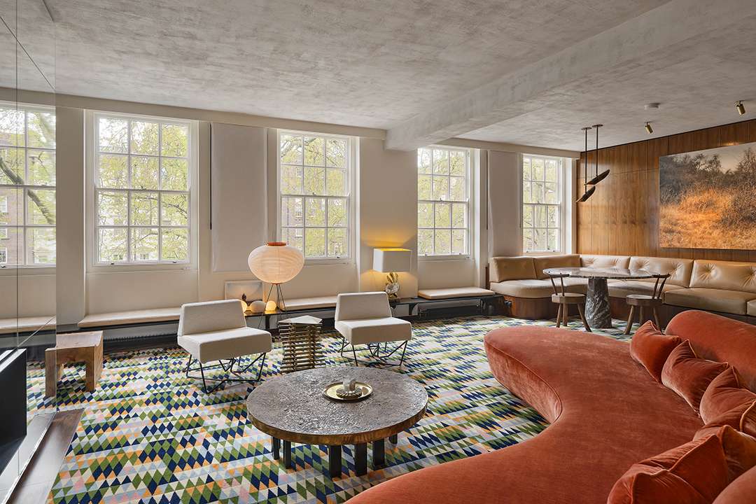 Living room with big red couch and separate beige seating bench