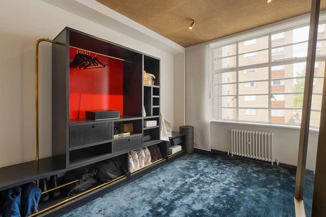 Blue carpeted closet with black and red built in shelves