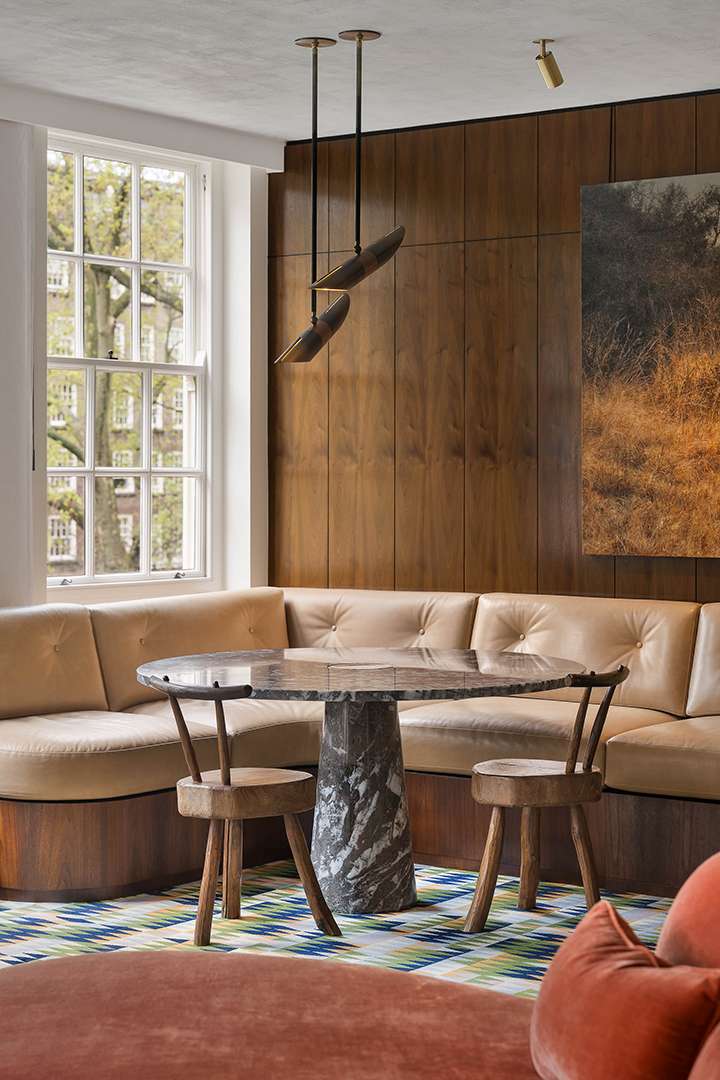 Beige lounge bench with marble table and red love seat
