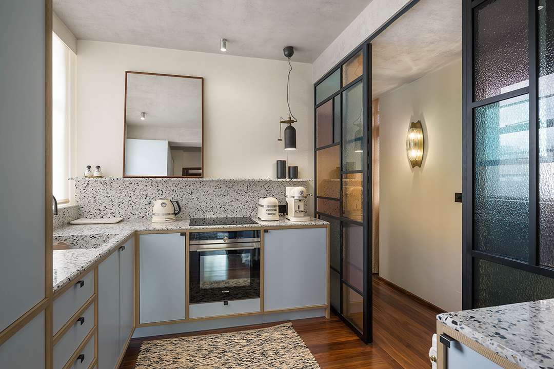 Kitchen with blue cabinets and black and white marble with sliding doors