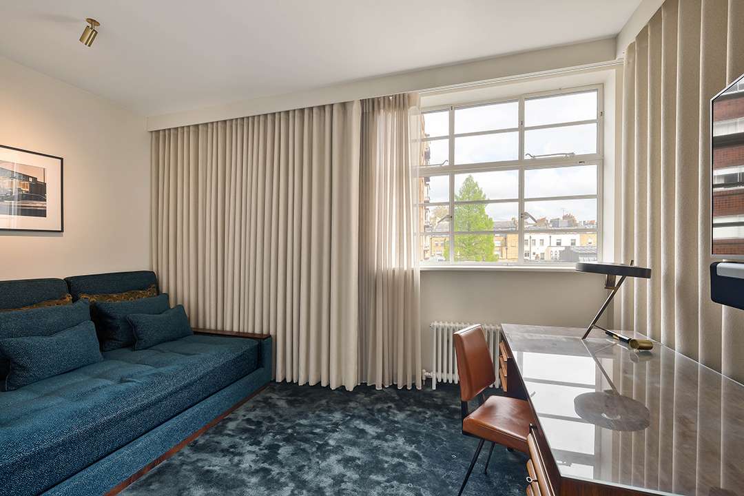 Office with blue couch and carpet