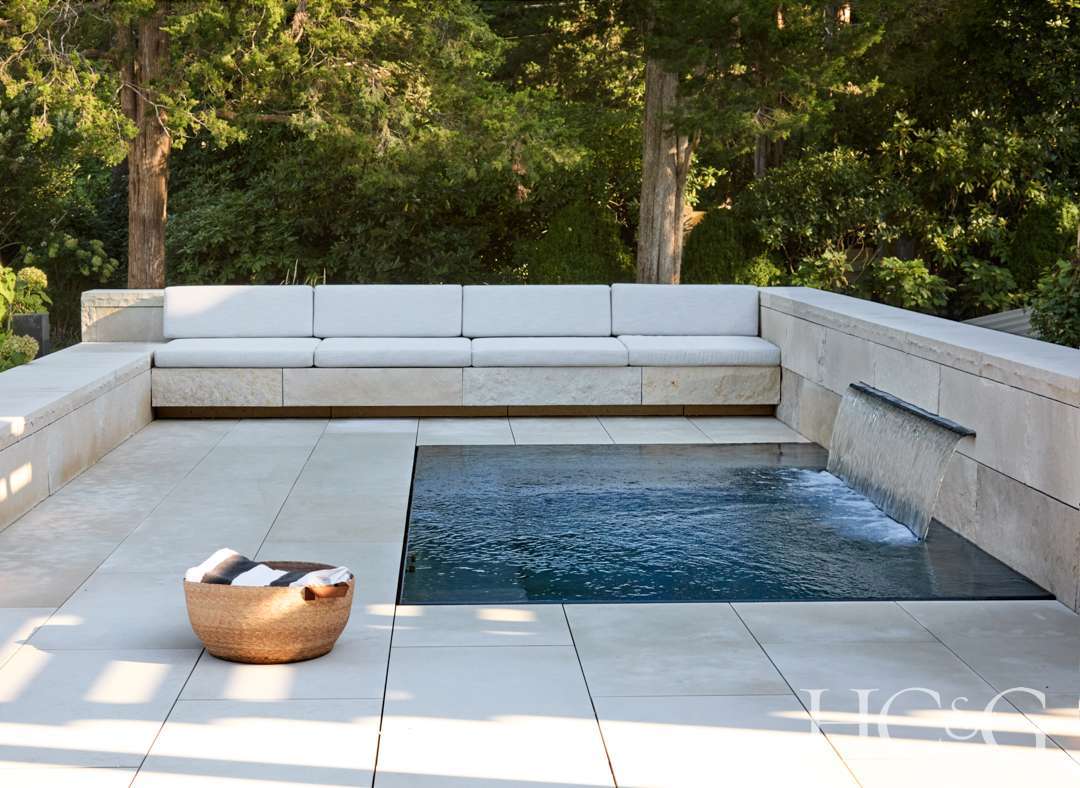 Waterfall hot tub with white banquette seating