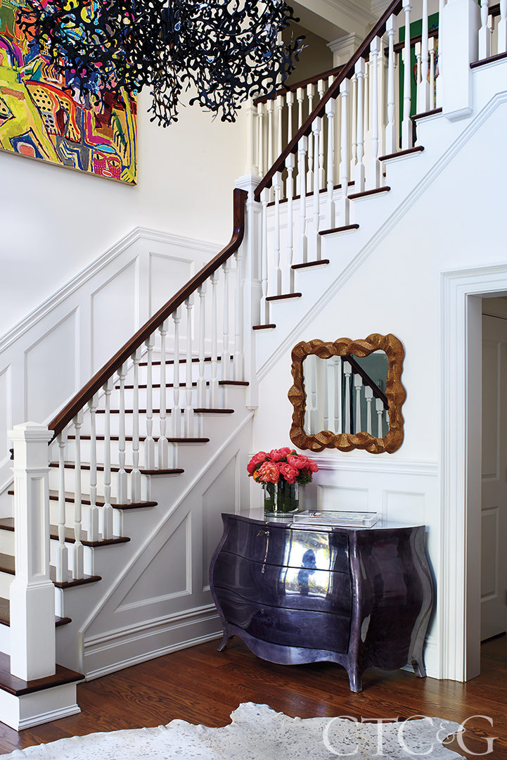Foyer with blue chest and white stairs