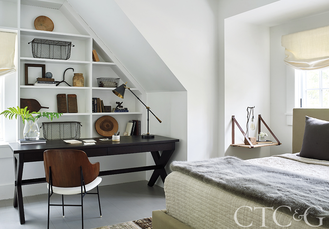 Office space in bedroom with white built-in shelves