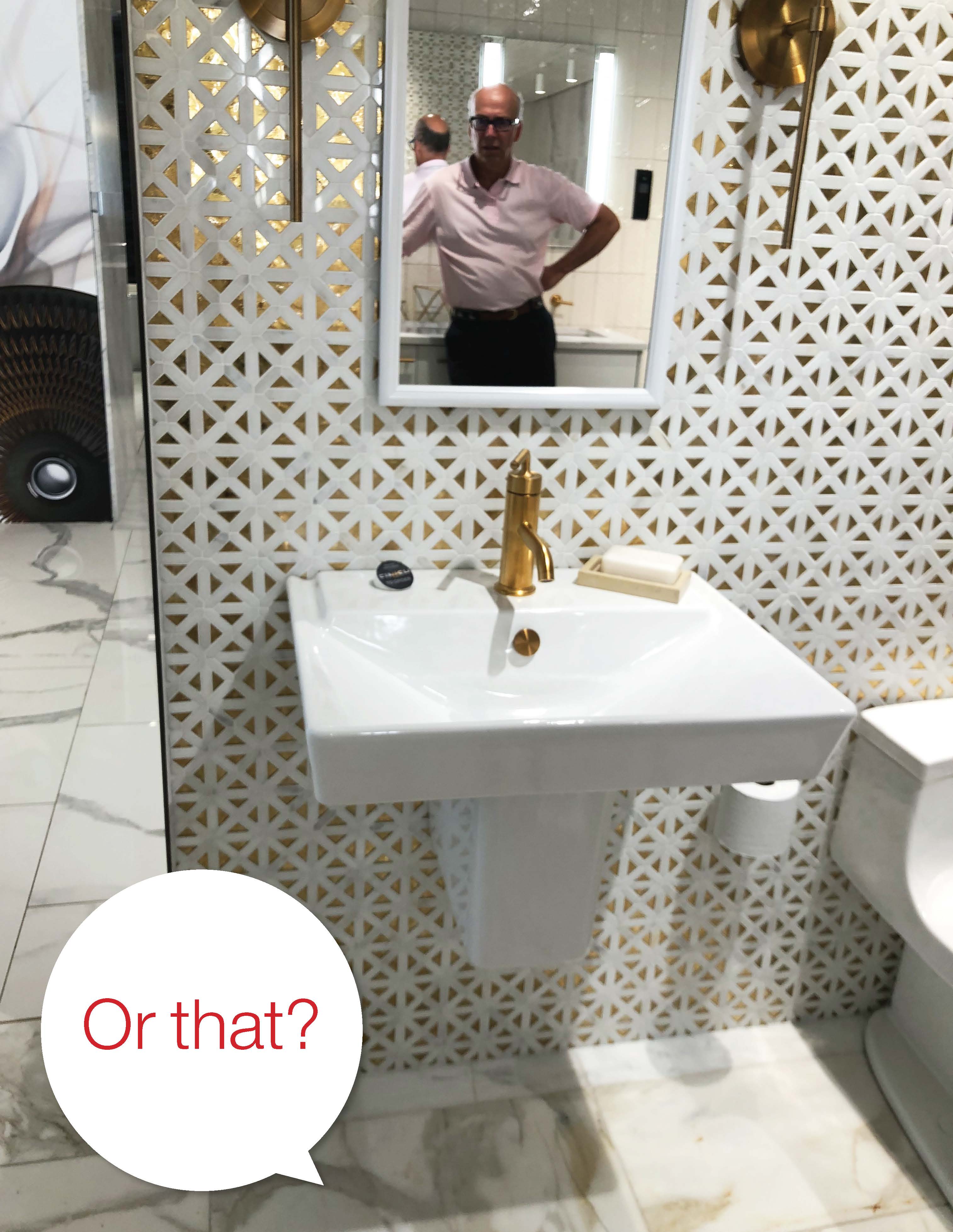 Kohler white sink with gold faucet and white and gold wallpaper