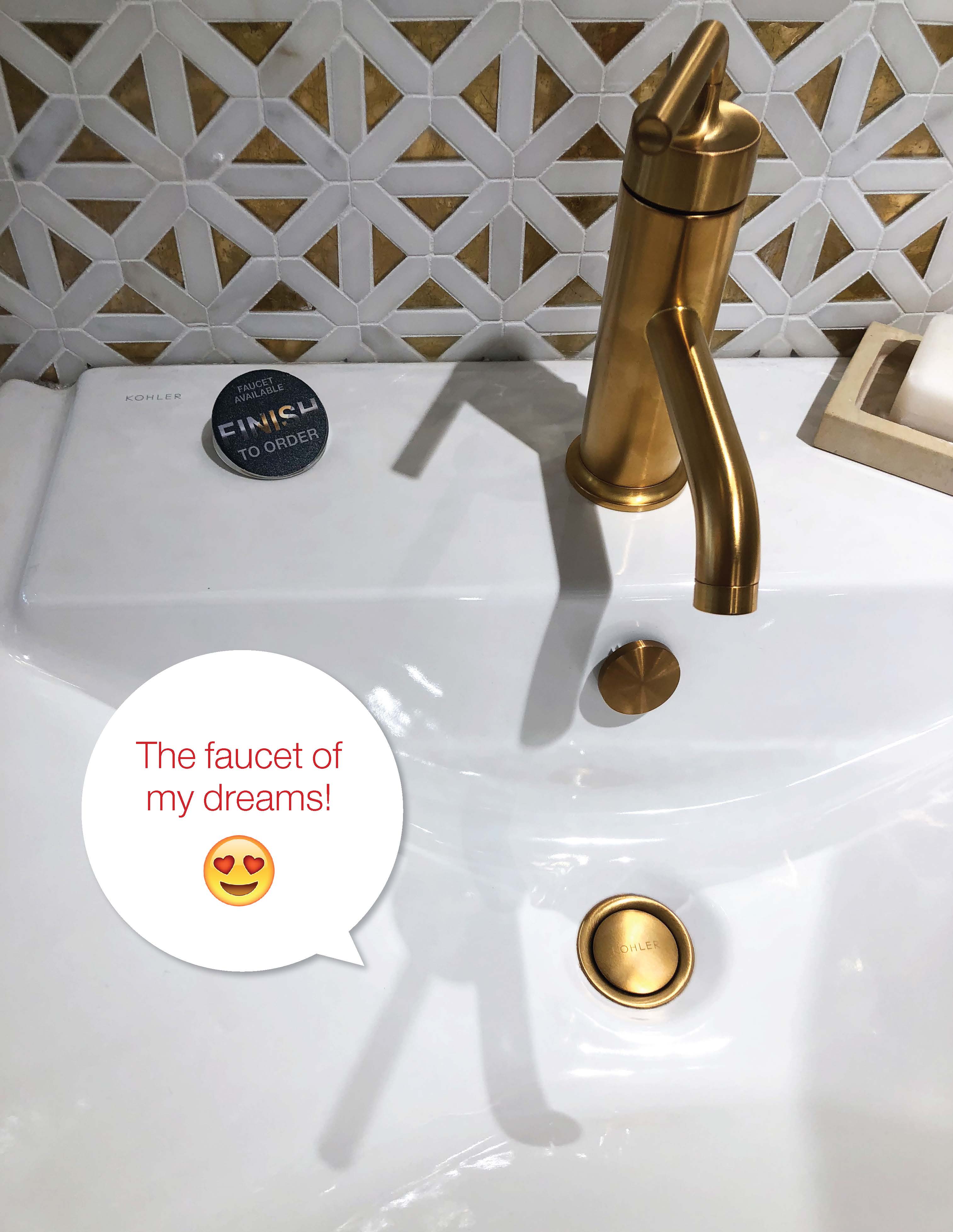 Kohler white sink with gold faucet and white and gold wallpaper